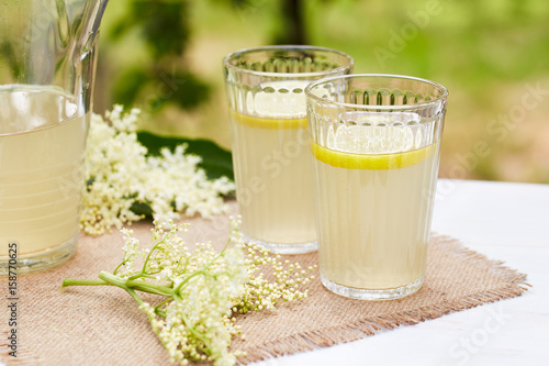 Two glasses of elderflower lemonade with fresh lemon