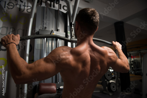 Muscular Man Doing Heavy Weight Exercise For Back