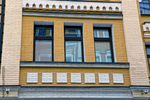 Три окна на современном кирпичном жилом здании