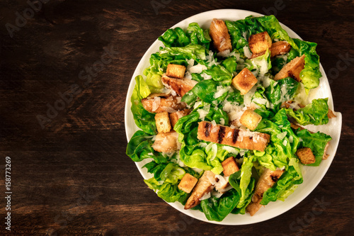Chicken Caesar salad on rustic background with copyspace