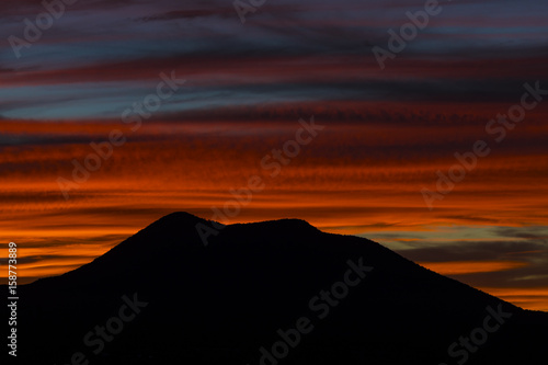 close up of a mountain with a colorful sunset behind it