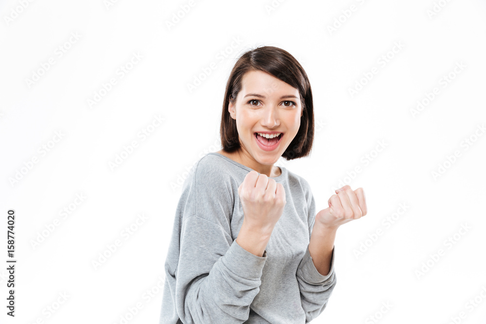 Happy young woman showing fists and looking at camera Happy young woman showing fists and looking at camera