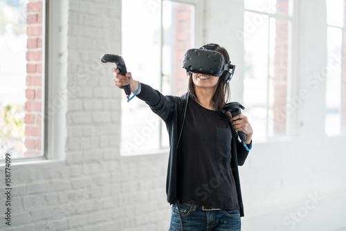 An asian woman wearing a virtual reality headset. photo