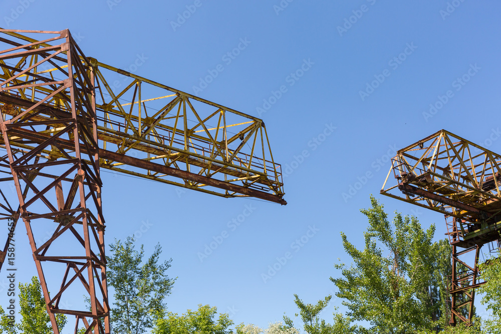 Part two rusty gantry cranes on the background of blue sky. Part two rusty gantry cranes on the background of blue sky.