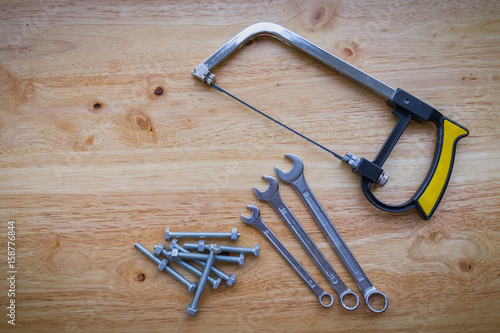 Tools set of wrenches, screw, saw, bolts and nuts on a wooden background
