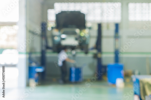 Blurred of car technician repairing the car in garage background, Interior of a car repair station,Cars servicing at Service station,car mechanic work at repair service station garage,vintage color.