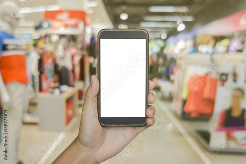 Man hand holding mobile smart phone on .Blur of city shopping people crowd at marketplace shoe shop abstract background, business concept.