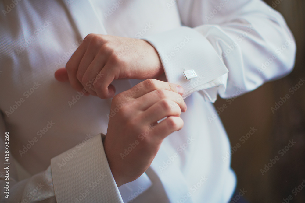 Man is fixing his cufflinks Man is fixing his cufflinks