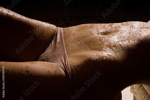 Female slim belly on a dark background.