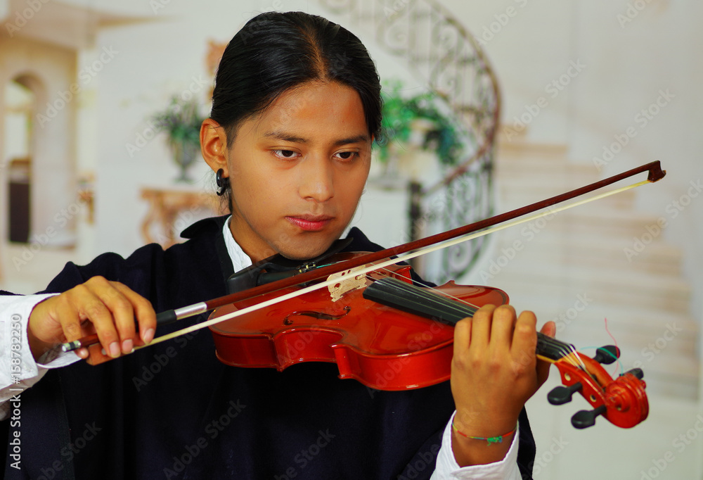 Indigenous young man from Otavalo, Ecuador, playing the violin Indigenous young man from Otavalo, Ecuador, playing the violin