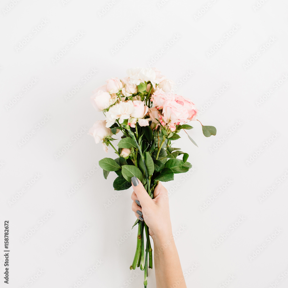 Fototapeta premium Beautiful pink rose flower bouquet in girls hand isolated on white background. Flat lay, top view. Floral composition