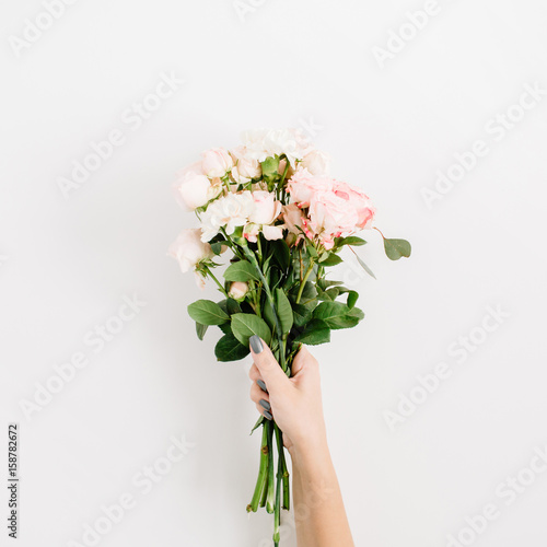 Beautiful pink rose flower bouquet in girls hand isolated on white background. Flat lay, top view. Floral composition