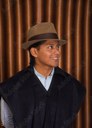 Portrait of indigenous young man wearing traditional hat and poncho from Otavalo, Ecuador photo