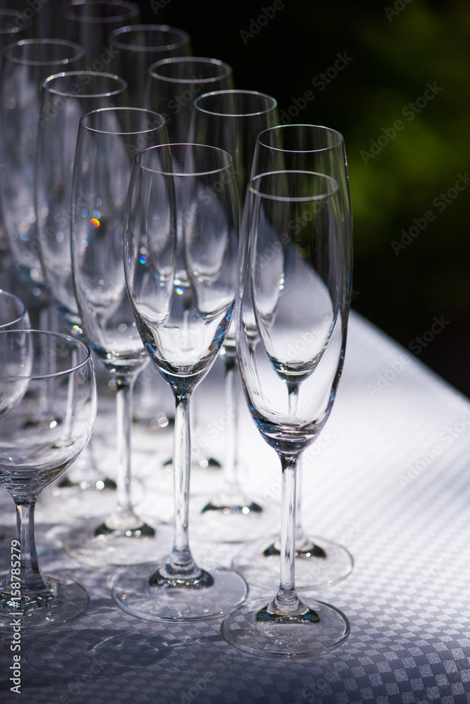 Empty glasses arranged on a table in the restaurant, cafe, or bar. Preparation for the birthday, wedding, or any celebration day. Empty glasses arranged on a table in the restaurant, cafe, or bar. Preparation for the birthday, wedding, or any celebration day.