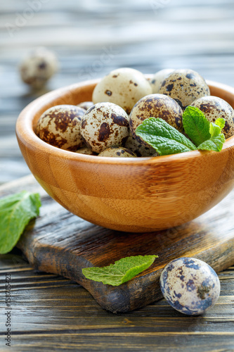 Quail eggs and mint leaves in a bowl.