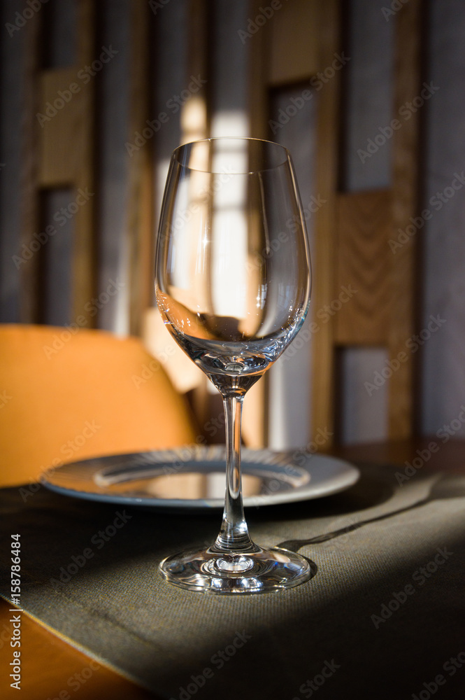 Empty glass arranged on a table in the restaurant, cafe, or bar. Preparation for the birthday, wedding, or any celebration day.