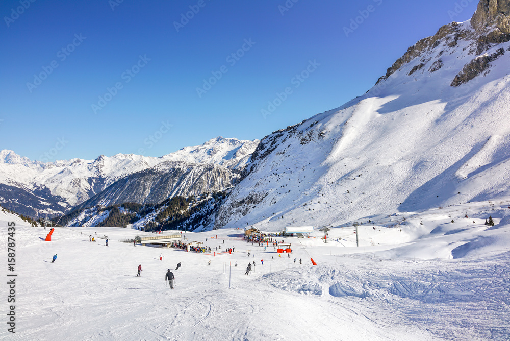 Skiers and snowboarders on the slopes in Courchevel winter resort, France.