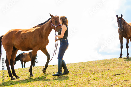 Jockey young girl petting brown horse © Voyagerix