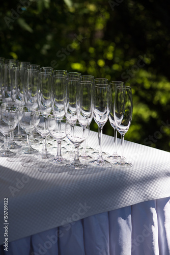 Empty glasses arranged on a table in the restaurant, cafe, or bar. Preparation for the birthday, wedding, or any celebration day.