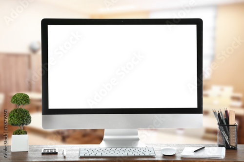 Computer on wooden table with blank white background photo