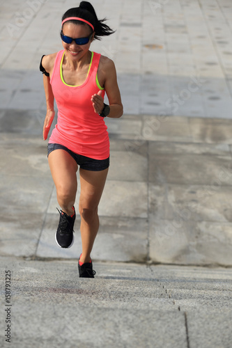 young fitness sports woman running up on stone stairs