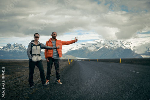 Travel hitchhiker couple on a road