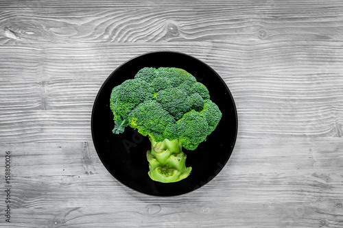 green fresh broccoli for fitness diet food on gray wooden table background top view photo