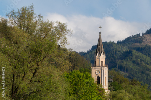 Church spire with forest in the background