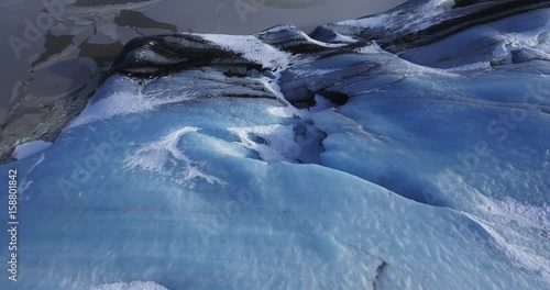 Tilt up aerial, scenic glaciers by Iceland lake