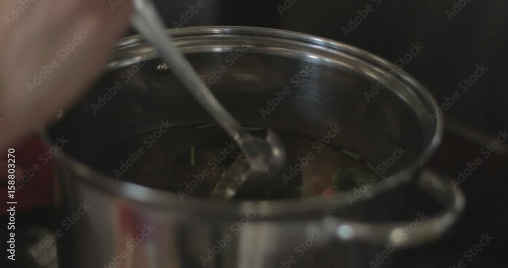 Stirring soup with a ladle Stirring soup with a ladle