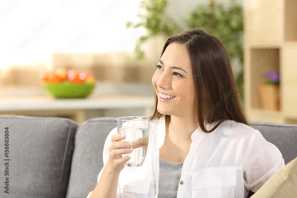 Woman thinking and holding a glass of water Woman thinking and holding a glass of water