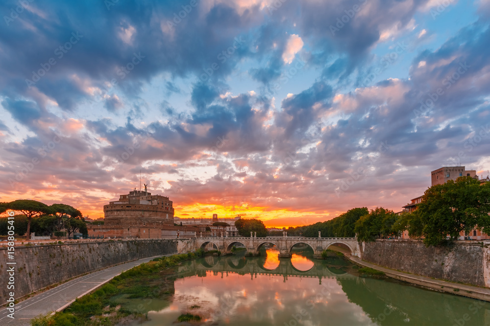 Saint Angel castle and bridge with mirror reflection in Tiber River during gorgeous dawn in Rome, Italy.
