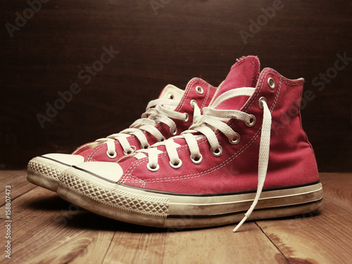 Red sneakers on wooden floor with retro effect