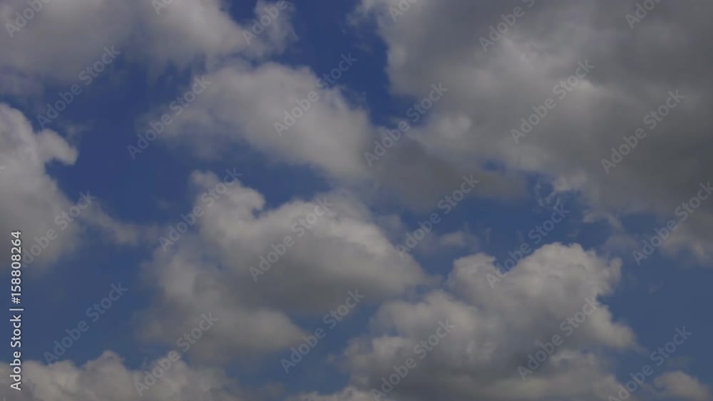 White puffy clouds move across a brilliant blue sky White puffy clouds move across a brilliant blue sky