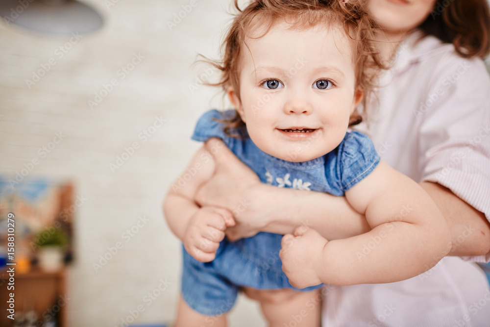 Portrait of cute little girl smiling looking at camera on mothers arms Portrait of cute little girl smiling looking at camera on mothers arms