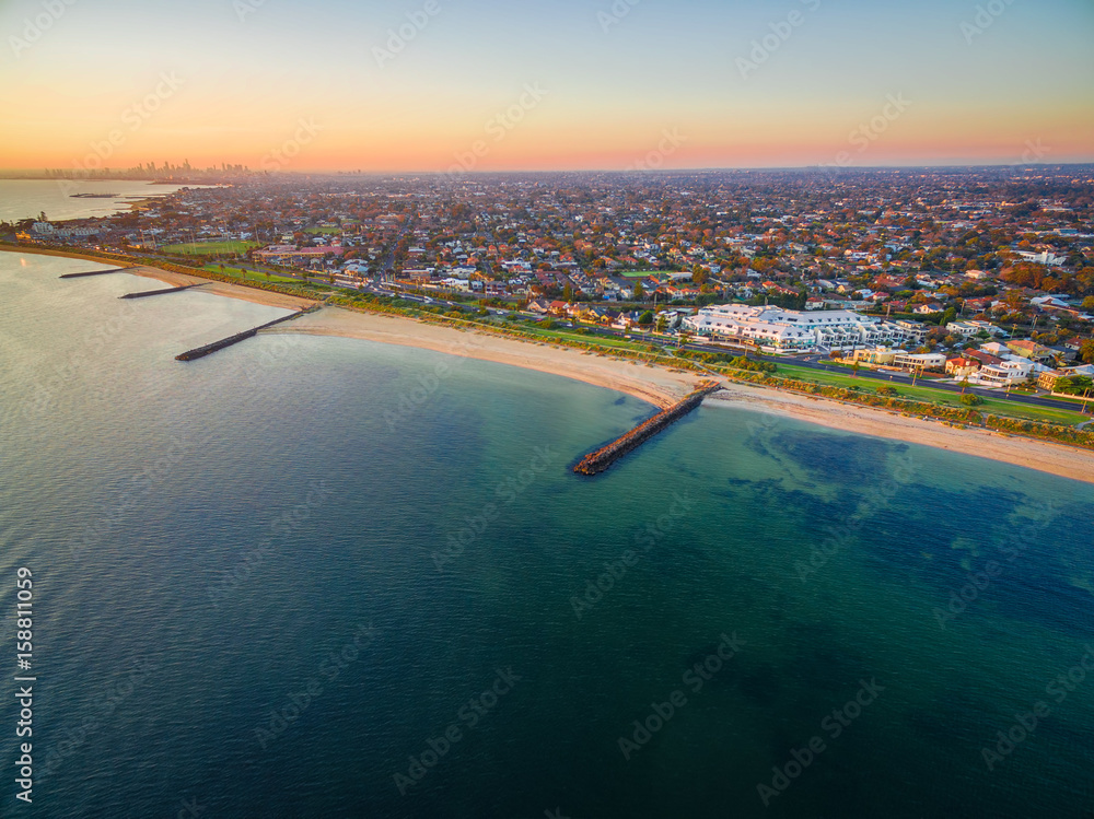 Aerial view of Port Phillip Bay and Melbourne coastline suburban living quarters at dusk