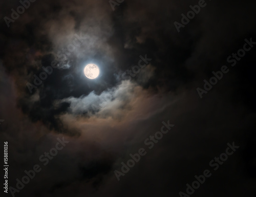 Full Moon among colorful swirling clouds