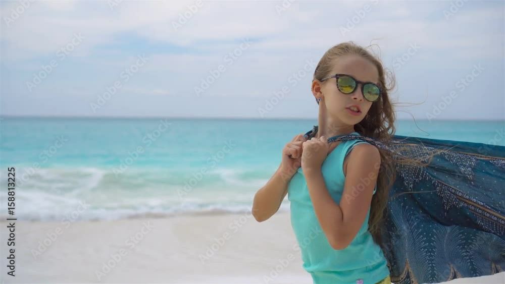 Cute little girl having fun running with pareo on tropical beach Cute little girl having fun running with pareo on tropical beach