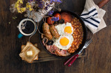 English breakfast with sausages, bacon, fried eggs, beans, toast, coffee