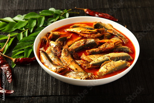 Spicy sardine curry on wooden background.