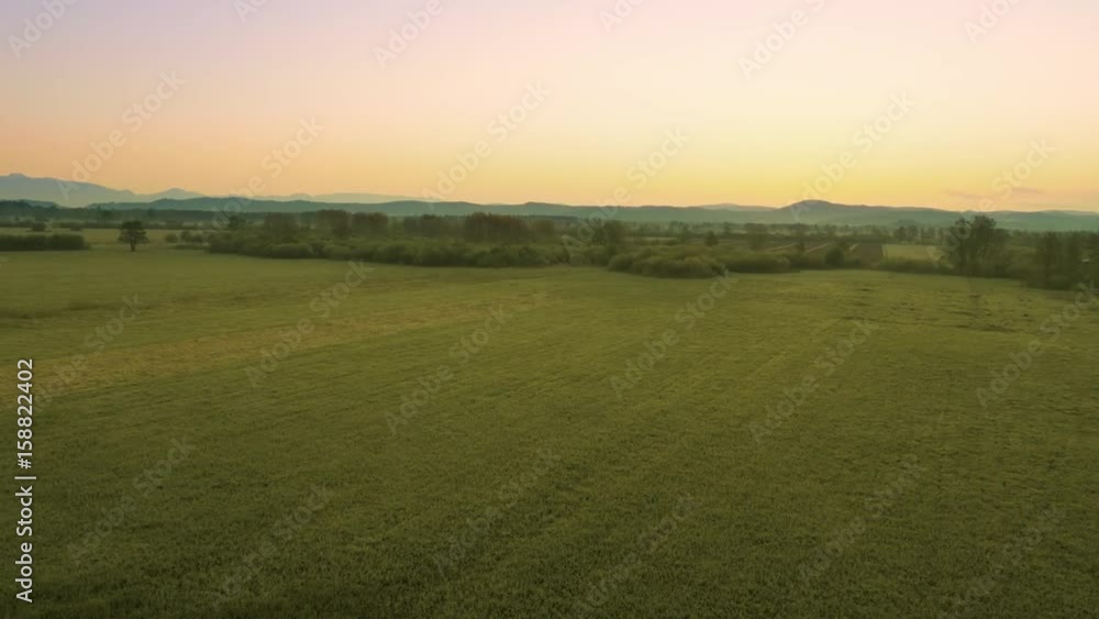 Aerial lift in total view showing a beautiful countryside seconds before sunrise in the summer.
Aerial lift in total view showing a beautiful countryside seconds before sunrise in the summer.