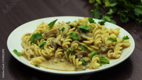 Italian Pasta with Mushrooms and Parsley on Whine Plate on Wooden Background