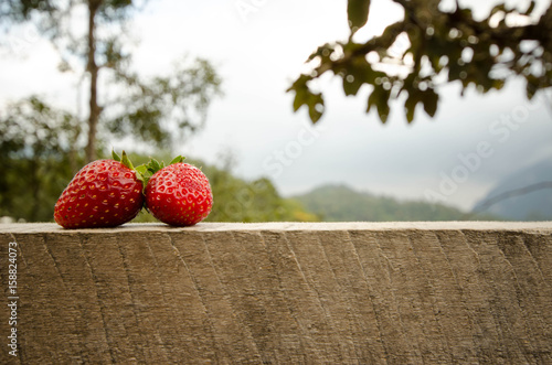 Strawberries placed on a wooden floor.