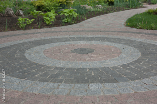 Sidewalk of granite of different colors in the form of a circle in the courtyard of the church