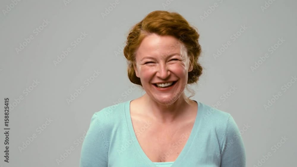 Actress of mid age sincerely laughing. Foxy woman smiling and laughing showing teeth in the studio. Actress of mid age sincerely laughing. Foxy woman smiling and laughing showing teeth in the studio.