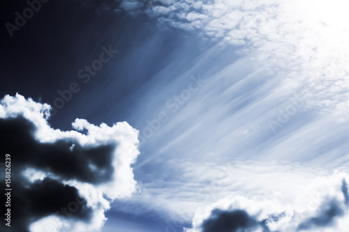 Sky with cumulus clouds and sun rays.