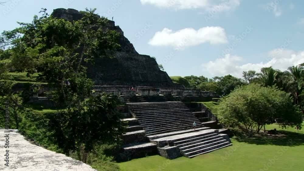 Tourist climbs up steps of temple El Castillo at Xunantunich