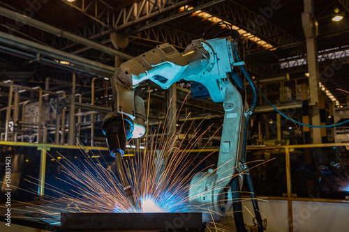 Robot is welding part in automotive factory 