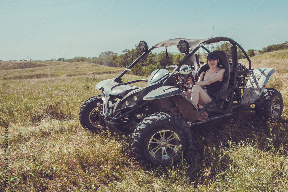 Buggy car at green field. Young woman driving, Almaty, Kazakhstan Buggy car at green field. Young woman driving, Almaty, Kazakhstan