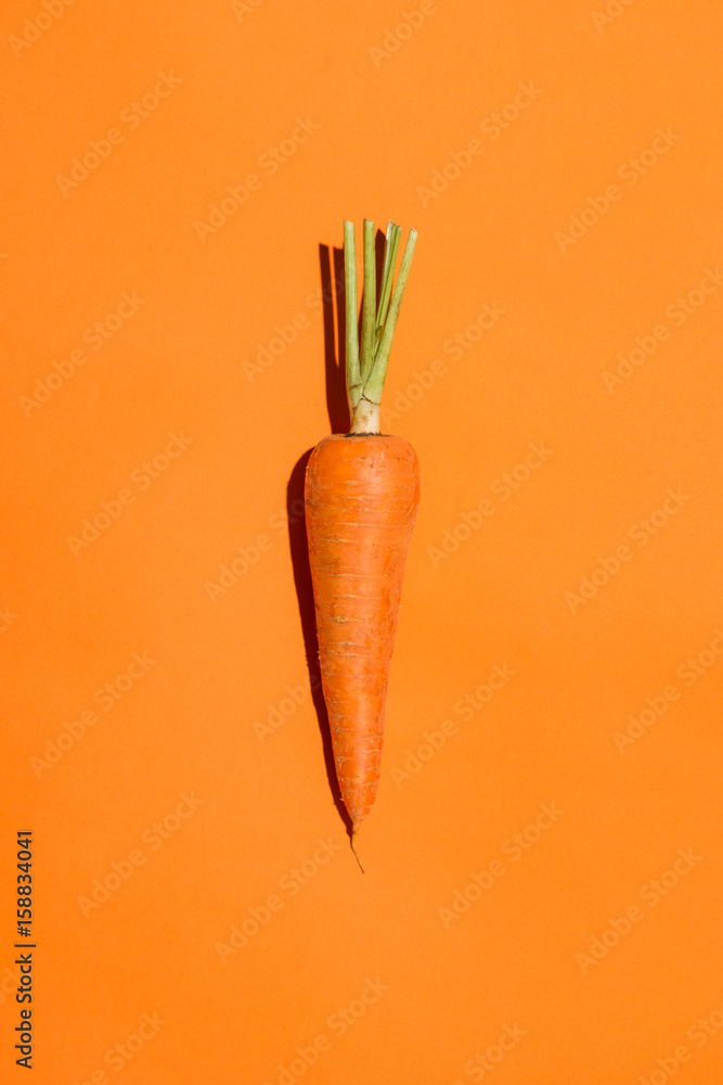 Top view of an carrot on orange background. - obrazy, fototapety, plakaty 